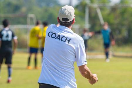 Trainer in witte polo geeft aanwijzingen